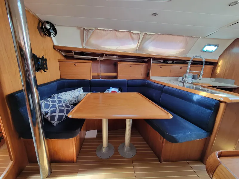 Slide: The Image of Interior of 2001 Jeanneau Sun Odyssey 37 sailboat with wooden table and blue seating. - 27