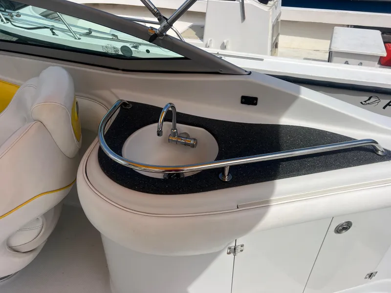 Slide: The Image of 2006 Crownline 240 EX boat interior with sink and seating area. - 10