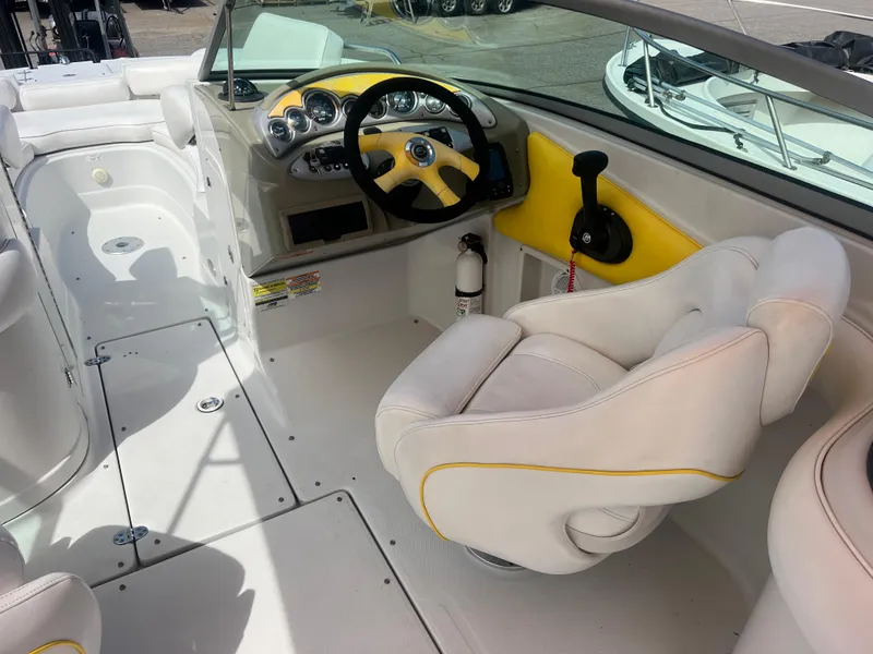 Slide: The Image of 2006 Crownline 240 EX boat interior with white and yellow seating, steering wheel, and dashboard. - 11