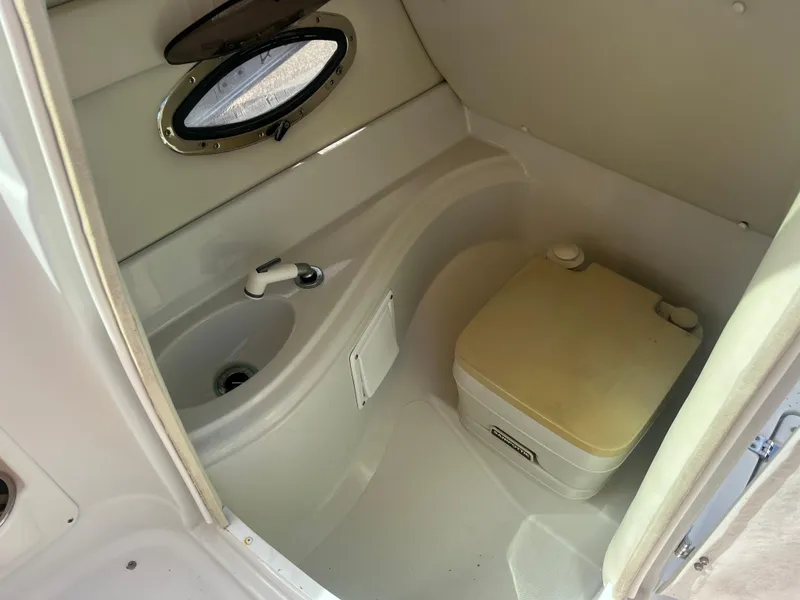 Slide: The Image of 2006 Crownline 240 EX boat interior with sink and portable toilet. - 13