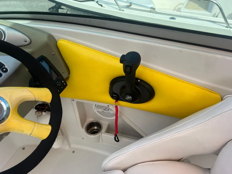 Slide: The Image of 2006 Crownline 240 EX boat cockpit with yellow accents and steering controls. - 14