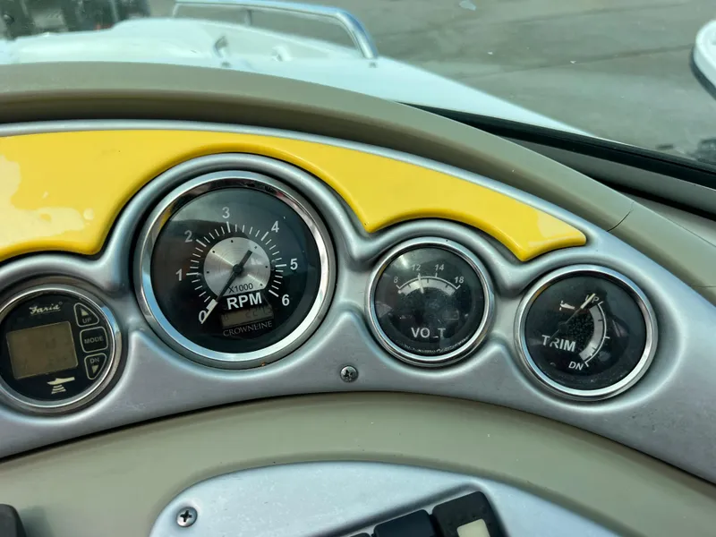 Slide: The Image of Dashboard of a 2006 Crownline 240 EX boat with RPM, voltage, and trim gauges. - 23