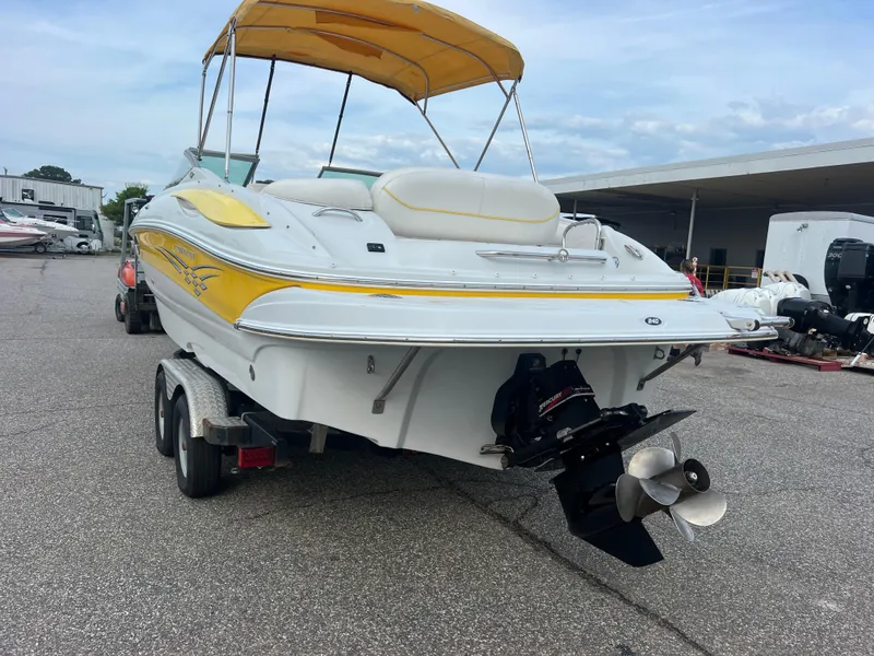 Slide: The Image of 2006 Crownline 240 EX boat with yellow accents on a trailer, featuring a canopy. - 3