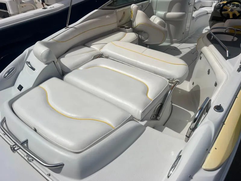 Slide: The Image of 2006 Crownline 240 EX boat interior with white cushioned seating and yellow accents. - 7