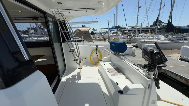 Slide: The Image of 2016 Jeanneau Velasco 37F yacht deck with marina view, featuring seating and ladder. - 26