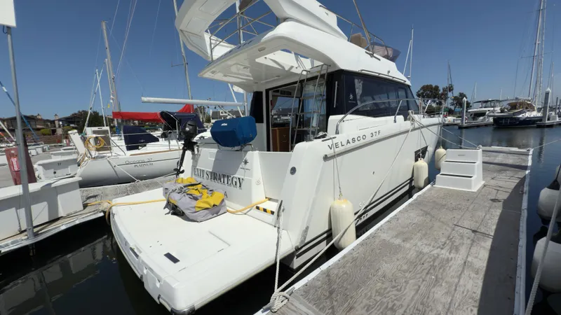 Slide: The Image of 2016 Jeanneau Velasco 37F docked at marina, rear view with clear sky. - 27
