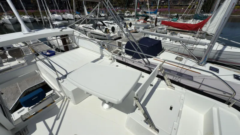 Slide: The Image of 2016 Jeanneau Velasco 37F yacht deck with seating, docked among other boats. - 6