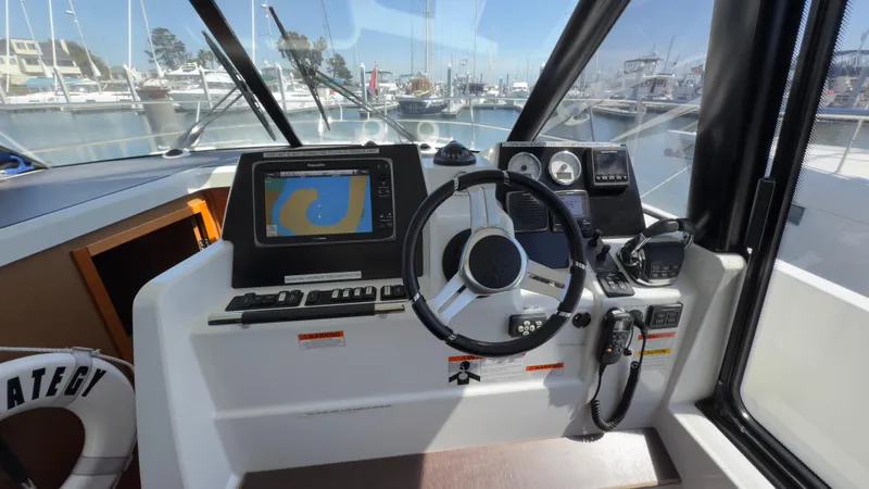 Slide: The Image of Helm of 2016 Jeanneau Velasco 37F with navigation system and steering wheel in marina setting. - 8