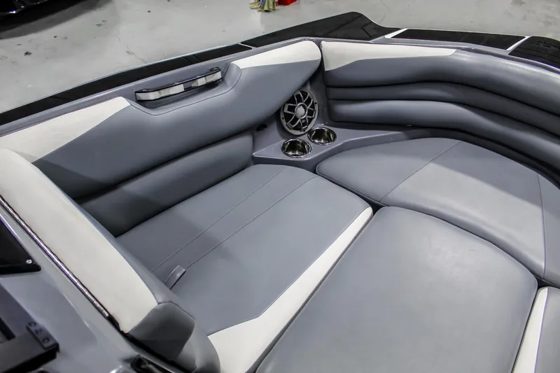 Slide: The Image of 2019 Axis A24 boat interior with gray and white seating, cup holders, and speaker. - 10