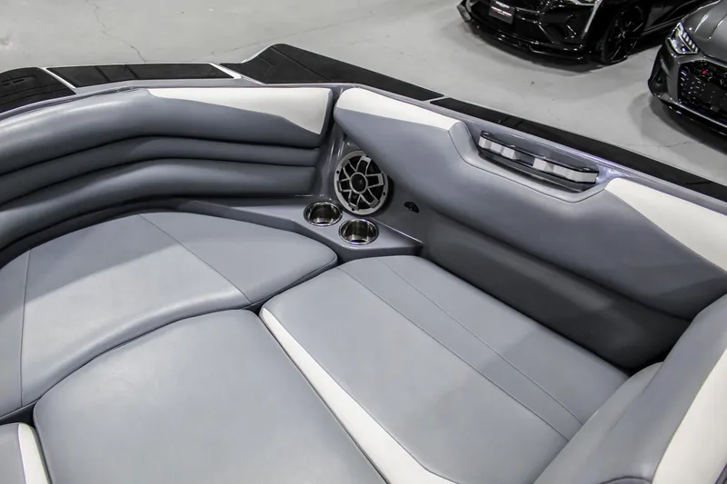 Slide: The Image of 2019 Axis A24 boat interior with gray seating, cup holders, and speaker. - 11