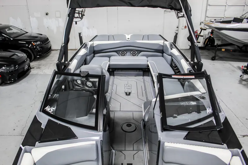 Slide: The Image of 2019 Axis A24 boat interior with gray seating and open windshield in a showroom. - 12