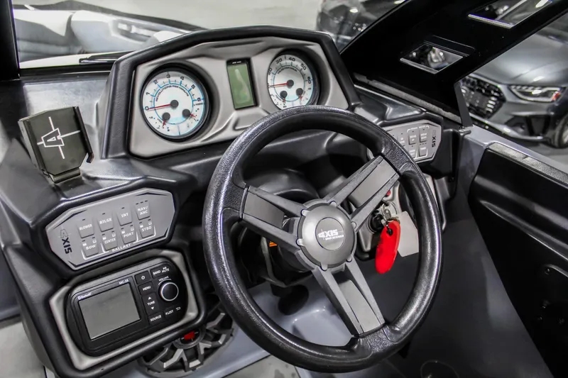 Slide: The Image of 2019 Axis A24 boat dashboard with steering wheel and control panels. - 14