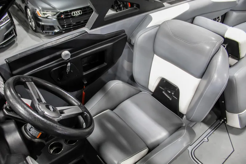 Slide: The Image of 2019 Axis A24 boat interior with gray and white seating, steering wheel, and dashboard. - 17