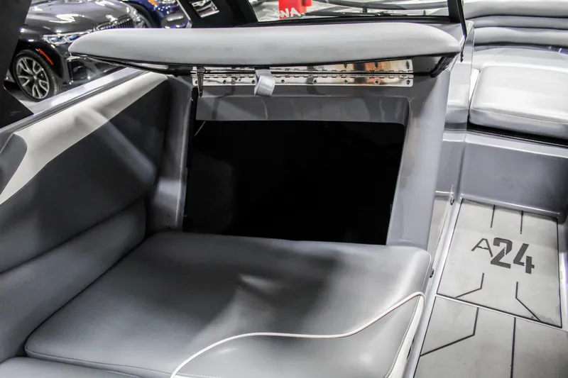 Slide: The Image of 2019 Axis A24 boat interior with gray seating and storage compartment. - 19