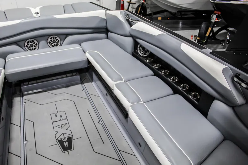 Slide: The Image of 2019 Axis A24 boat interior with gray seating and built-in speakers. - 20