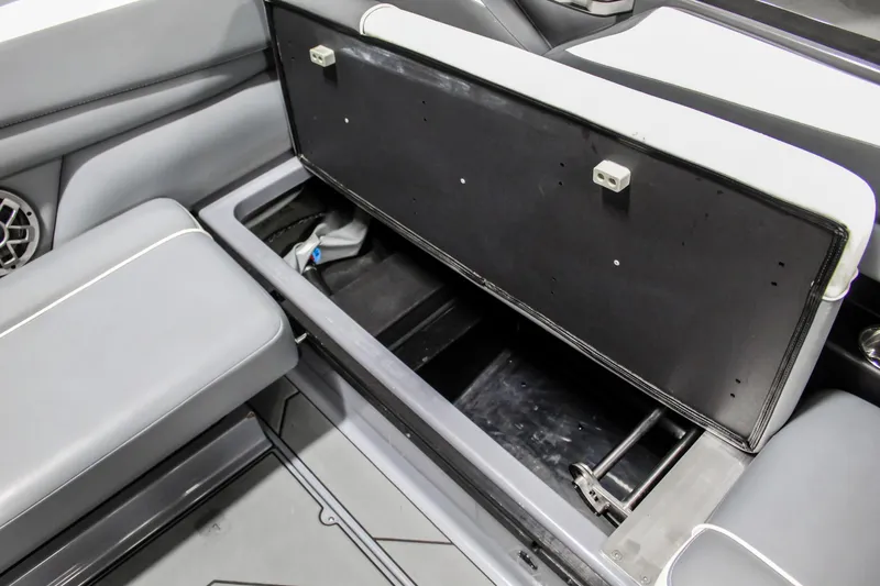 Slide: The Image of 2019 Axis A24 boat interior storage compartment with open lid, showcasing spacious seating and storage. - 22