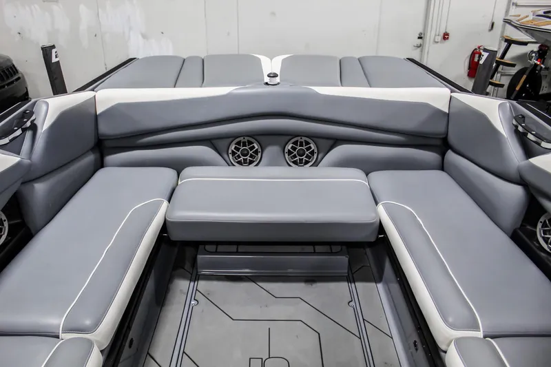 Slide: The Image of 2019 Axis A24 boat interior with gray seating and built-in speakers. - 23