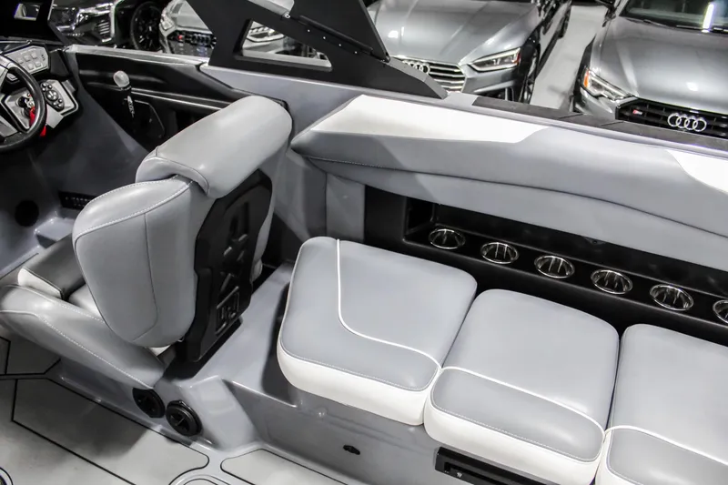 Slide: The Image of 2019 Axis A24 boat interior with gray seating and modern dashboard design. - 26