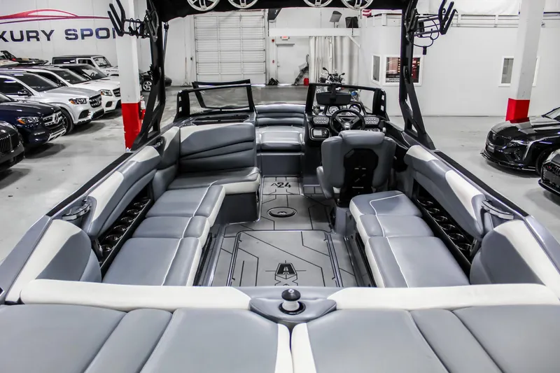 Slide: The Image of 2019 Axis A24 boat interior with gray seating and modern dashboard in a showroom. - 29