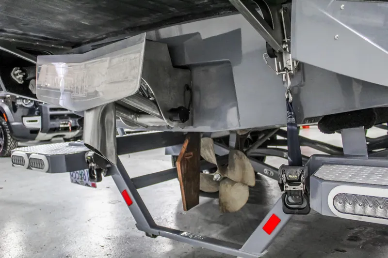 Slide: The Image of 2019 Axis A24 boat underside showing propeller and trailer details in a garage setting. - 35