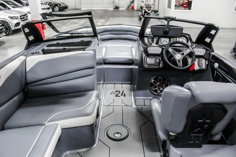 Slide: The Image of 2019 Axis A24 boat interior with gray seating and modern dashboard. - 9