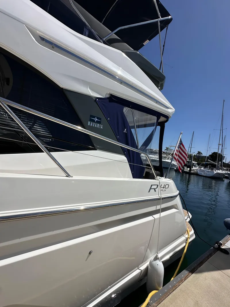 Slide: The Image of 2024 Bavaria R40 yacht docked at marina with American flag. - 35
