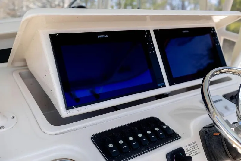 Slide: The Image of 2017 Grady-White Canyon 336 dashboard with dual Simrad displays and control panel. - 15