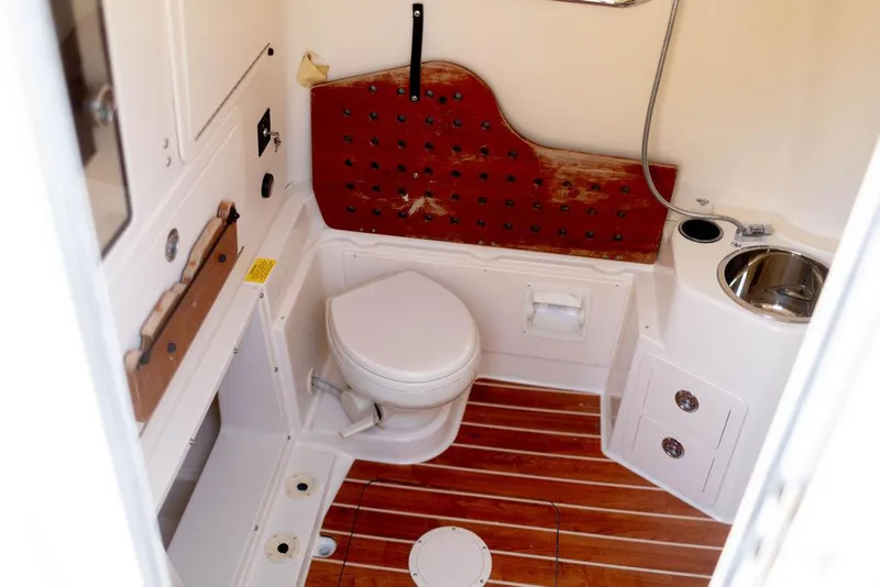 Slide: The Image of 2017 Grady-White Canyon 336 boat bathroom with wooden flooring and compact amenities. - 19