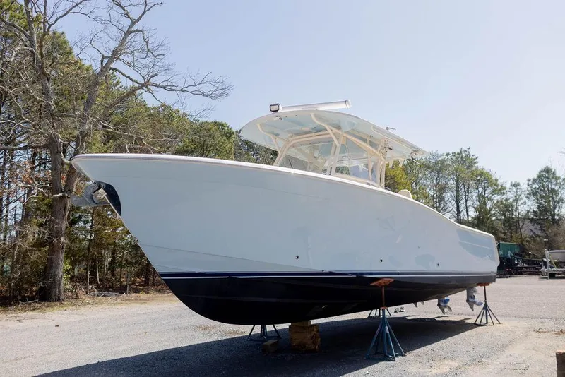 Slide: The Image of 2017 Grady-White Canyon 336 boat on stands, surrounded by trees. - 2