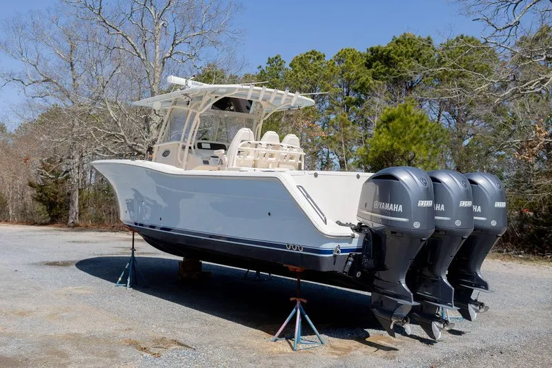 Slide: The Image of 2017 Grady-White Canyon 336 boat with triple Yamaha engines on stands outdoors. - 4