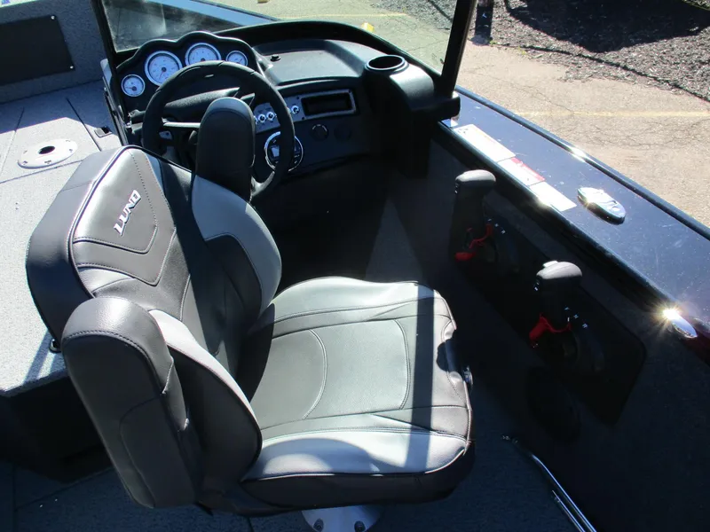 Slide: The Image of 2025 Lund 1875 Fisherman Sport boat interior with steering wheel and seat. - 3