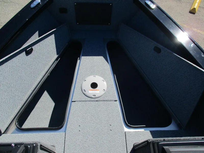 Slide: The Image of 2025 Lund 1875 Fisherman Sport boat interior with storage compartments and carpeted flooring. - 5