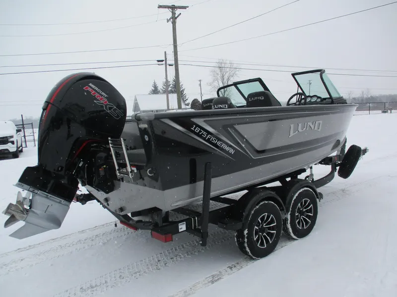 Slide: The Image of 2025 Lund 1875 Fisherman Sport boat on trailer in snowy setting. - 12