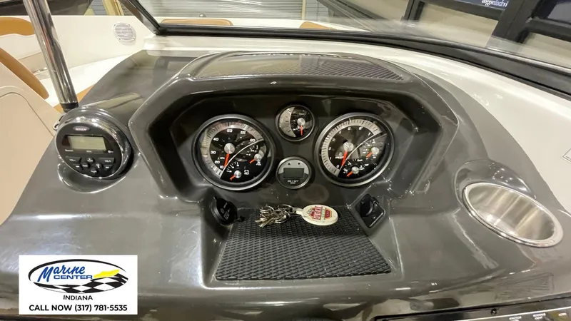 Slide: The Image of 2019 Bayliner VR 5 dashboard with gauges and keys, Marine Center Indiana contact info. - 3