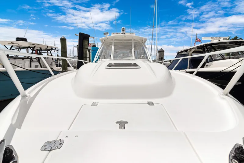 Slide: The Image of 2004 Intrepid 377 Walkaround boat docked under a clear blue sky. - 23