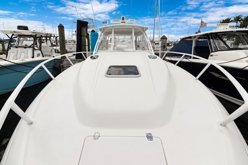Slide: The Image of 2004 Intrepid 377 Walkaround boat docked at marina under blue sky. - 24