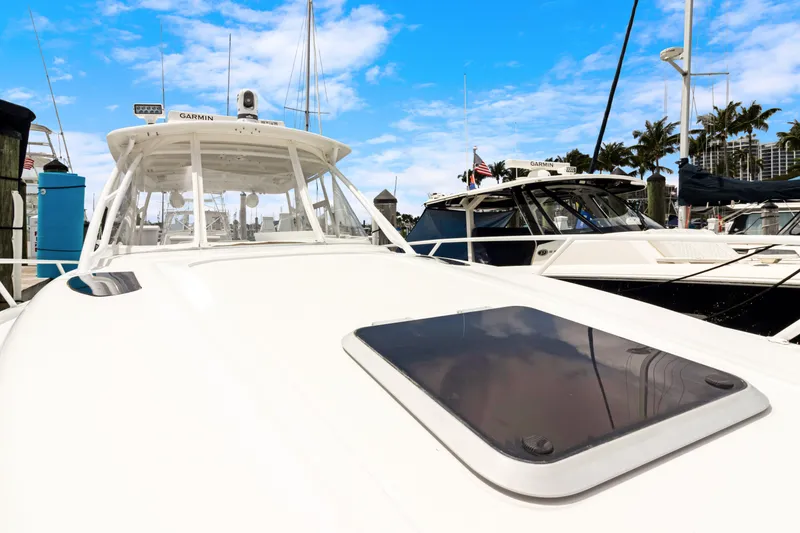Slide: The Image of 2004 Intrepid 377 Walkaround boat docked at marina under blue sky. - 26