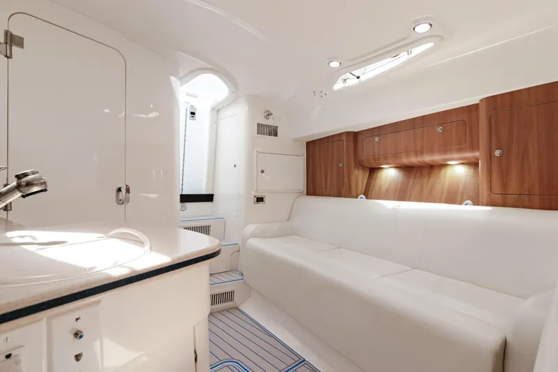 Slide: The Image of Luxurious interior of a 2004 Intrepid 377 Walkaround boat with white seating and wood accents. - 32