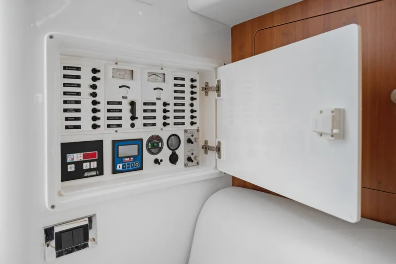 Slide: The Image of Electrical panel inside 2004 Intrepid 377 Walkaround boat, featuring various switches and gauges. - 35