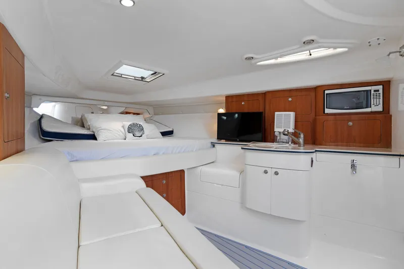 Slide: The Image of 2004 Intrepid 377 Walkaround cabin interior with bed, kitchenette, and seating area. - 39