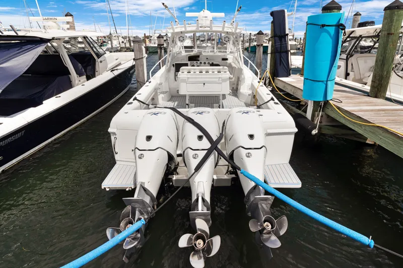 Slide: The Image of 2004 Intrepid 377 Walkaround boat docked with triple outboard engines. - 50