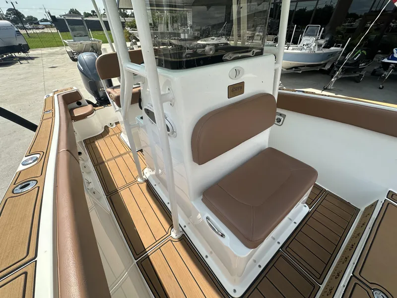 Slide: The Image of 2019 Clearwater 2300 Center Console boat interior with brown seating and wood-style flooring. - 16