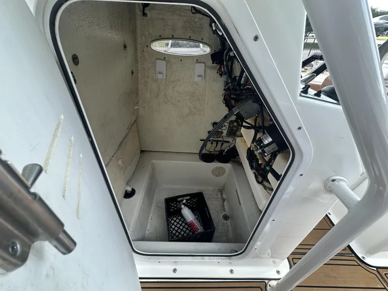 Slide: The Image of 2019 Clearwater 2300 Center Console boat storage compartment with wiring and crate. - 17