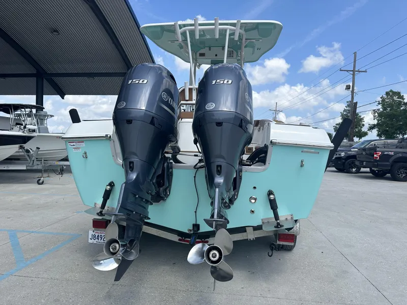 Slide: The Image of 2019 Clearwater 2300 boat with dual Yamaha 150 engines, parked outdoors. - 2