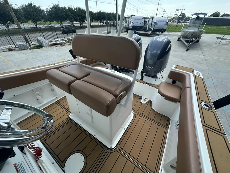 Slide: The Image of 2019 Clearwater 2300 boat interior with brown seating and dual outboard engines. - 7