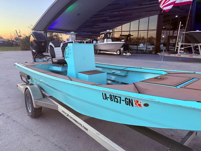 Slide: The Image of 2022 Custom Uncle J 19 Bay Center Console Aluminum boat on trailer, parked outside dealership. - 8