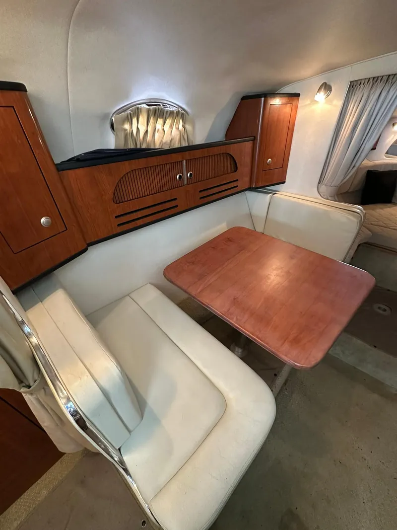 Slide: The Image of 2007 Sea Ray 280 Sundancer cabin interior with dining area and wooden cabinetry. - 10