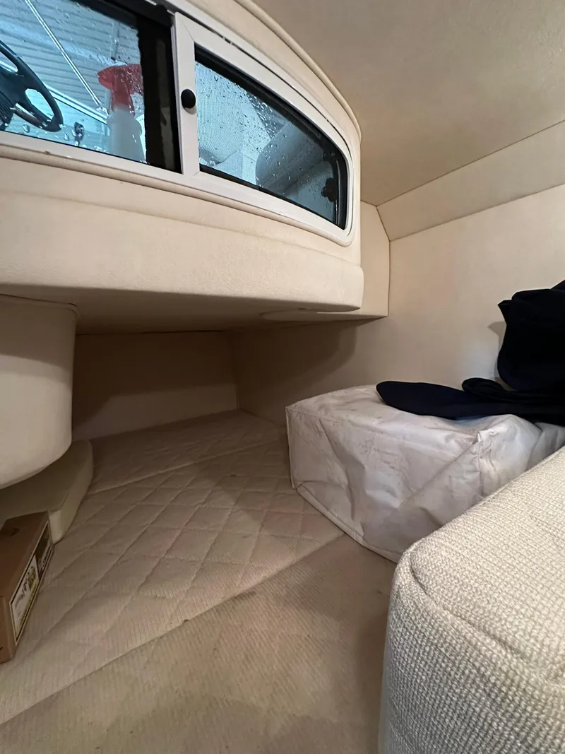 Slide: The Image of 2007 Sea Ray 280 Sundancer cabin interior with beige upholstery and window. - 12