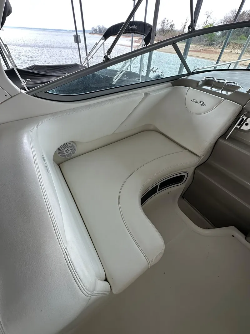 Slide: The Image of 2007 Sea Ray 280 Sundancer interior seating with beige upholstery and lake view. - 7