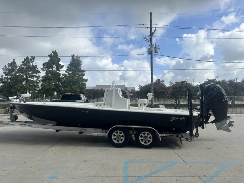 Slide: The Image of 2012 Yellowfin 24 Bay boat on trailer, parked outdoors under cloudy sky. - 19